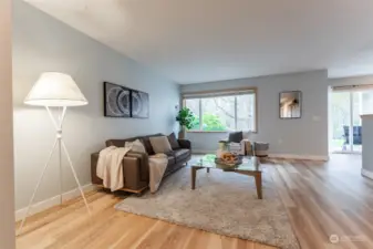 Large living room window look out to the wooded area over the still blooming hydrangea.