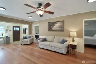 Living room with ceiling fans, entry to bedroom 1 and 2