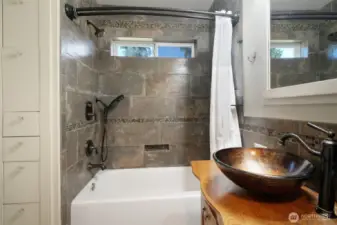 Bathroom with custom sink, tile, and showering options, storage on left