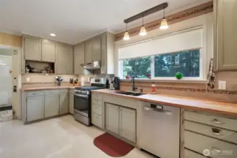 Kitchen with butcher block counters, large window for natural lighting, stainless steel appliances that are less than 3 years old