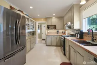Kitchen with butcher block counters, spice rack, stainless steel appliances that are less than 3 years old