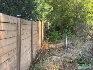 There is a buffer between the property line and the neighboring fence.