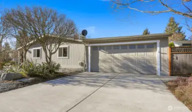 Front view with 2 car attached garage and level driveway with additional 2 uncovered parking spaces