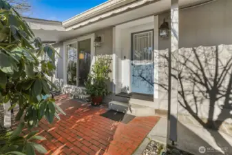 Covered front porch entry and patio overlooking the community greenbelt with trail access