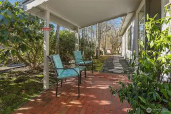Covered front porch entry and patio overlooking the community greenbelt with trail access