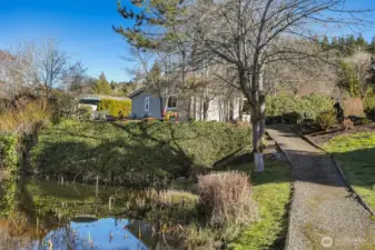 View of the back yard and house from the Community greenbelt and trail overlooking the pond
