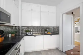 Kitchen flows to back hall with pantry