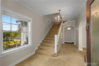 Elegant entry way with crystal chandelier and wide staircase