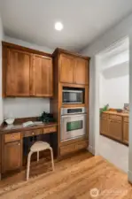 Butler pantry in the background with additional storage. Coffee bar? Wine bar?    Intentional work from home space in the kitchen area. Owner put in a microwave for their own use, but this space also accommodates a convection microwave oven.