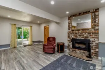 Warm up by the woodstove in this cozy home’s rec room.