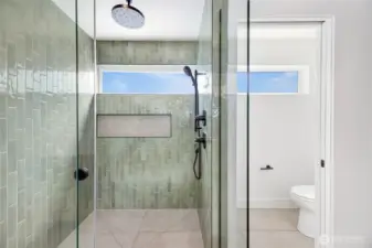 Primary shower with heated floors and rain shower head.