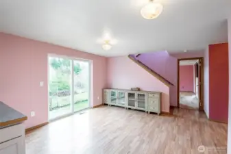 Another look at kitchen dining area with main floor Primary bedroom just beyond the staircase.