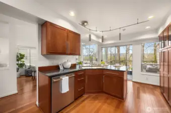 The L-shape island anchors the Kitchen footprint with extra counter space and storage cabinetry