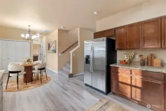 he pantry is inside those white doors. Down that hall way is a half-bath to the left, the large laundry straight ahead, and the door to the garage. Photo is virtually staged.