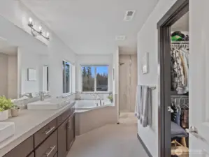 A true sanctuary! This luxurious primary suite features a spacious layout, serene views, and a spa-like ensuite with a soaking tub, dual vanities, and a walk-in shower.