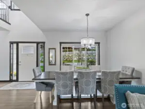 This inviting dining area offers plenty of space for gatherings, featuring elegant lighting, large windows that bring in natural light, and an open flow to the kitchen, perfect for entertaining.