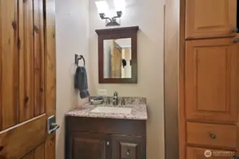 Half bath located next to the laundry room and hallway that leads to the side entrance & deck.