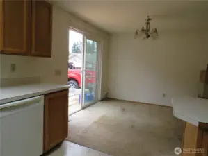 Dining area with slider to the deck for a BBQ and fenced backyard