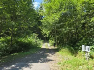 Neighbor to the West. Their gate as they drive thru this property to the West. You can walk in to view the property,  but we don't have gate code at this time.