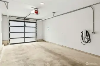 The wonderfully convenient connected tandem 2-car garage in this home has a Tesla EV-charger and extra storage space too.