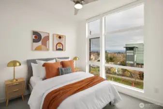The second floor offers two nice-sized bedrooms and full bath.  Looking east this bedroom enjoys broad vistas of the Cascades and territorial landscapes.  Tall ceiling heights continue, cozy carpeted floors, closet built-ins and remote shades add to the ambience.