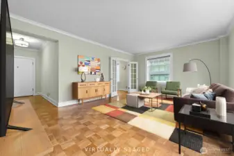 Living room view looking into the dining area.  French doors lead to the dining area and vintage kitchen.    Virtually Staged
