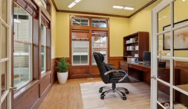 Elegant den with double-door entry and rich wood wainscoting and built-in shelving—perfect for a home office. *Virtually Staged*