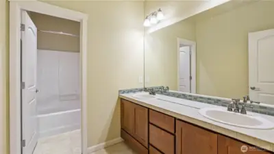 Full bath on upper level with double sinks.