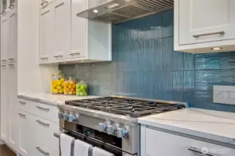 Miele 6-burner dual fuel stove, oven with steam function and Kobe hood fan. Pantry with pull out shelves at far left.