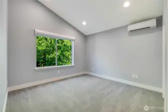 Large third bedroom with vaulted ceilings and a ductless heat pump for customizable comfort. Closet is out of view, far right.