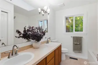 Upper-level bathroom with dual sinks and tub/shower combo