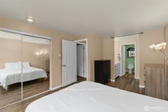 Sliding closet doors with mirrors and primary bath off bedroom
