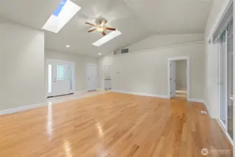 View from the dining area toward the front door, door to the garage, primary bedroom and laundry room