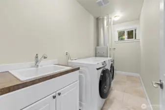 Laundry room with tankless water heater and furnace.