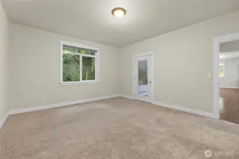Additional view of primary bedroom looking toward exterior door leading to the covered deck