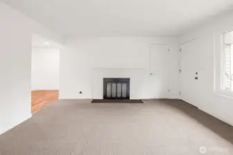 Comfortable front living space with new carpet, wood buring fireplace, and ductless mini split