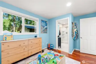 3rd bedroom with large california closet and views of the courtyard and pocket door to bathroom.