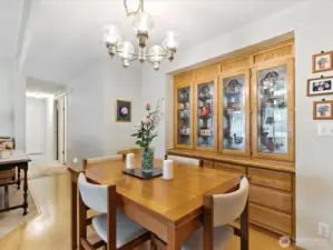 A built-in cabinet anchors the space and provides both storage and display, while the adjacent area offers the perfect spot for a formal dining table—ideal for hosting gatherings or special occasions.