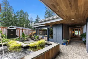 Garden patio greets you as you enter this custom home with timeless design! This gorgeous koi pond could become a water feature or a plunge pool for hot days. It's 4 feet deep!