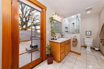 Primary bathroom with a door leading out the deck and hot tub.