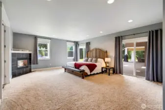 Cozy fireplace in the Primary bedroom with sliders out to the patio