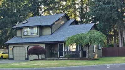 Welcome home to 25608 68th Ave E—this striking front exterior shot showcases the home’s curb appeal with a lush green lawn, long driveway, and charming covered porch. Surrounded by serene trees and natural privacy, this property blends country comfort with Northwest style. Ideal for buyers seeking peace, space, and practicality.