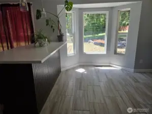 Bay windows create a bright and inviting breakfast nook, perfect for soaking in the morning light or watching the wildlife in your private yard.