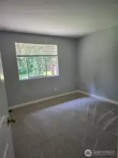 Enjoy a peaceful view of the tree-lined backyard from this bright and airy bedroom. Soft natural light and newly updated carpet make this a cozy and restful retreat.