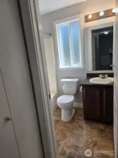 This modern guest bathroom features a sleek countertop, classic vanity, and full wall mirror.