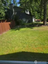 Expansive side yard with mature trees and terraced garden beds offers a quiet, green buffer from neighboring homes—perfect for play, gardening, or future landscaping dreams.