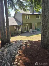 The home’s rear exterior features large windows and a sliding glass door opening to the patio—inviting natural light into the living space and making backyard access seamless.
