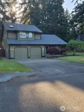 Double garage and spacious driveway offer ample parking at this beautifully maintained home with inviting curb appeal, mature trees, and vibrant lawn in a serene neighborhood setting.