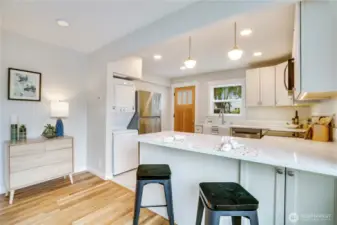 Bright and modern, this fully updated kitchen features a stylish new island with breakfast bar seating plus sleek in-ceiling and pendant lighting.