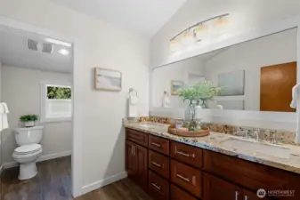 The primary bathroom is spacious and luxurious, featuring quartz countertops and tile floors.